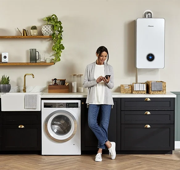 Modern kitchen with woman using smartphone.