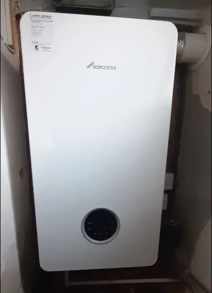 Modern wall-mounted boiler in a utility room.