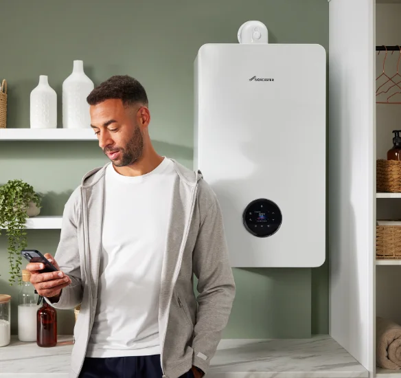 Man using smartphone near smart boiler.