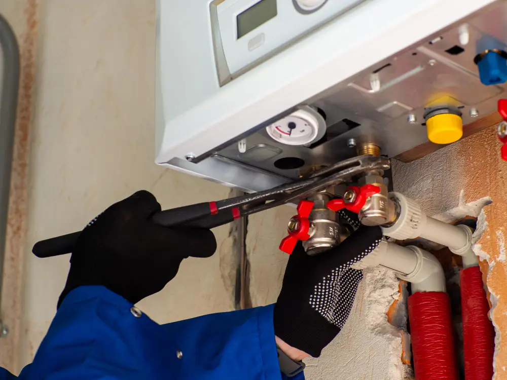 Technician tightening boiler pipes with a wrench